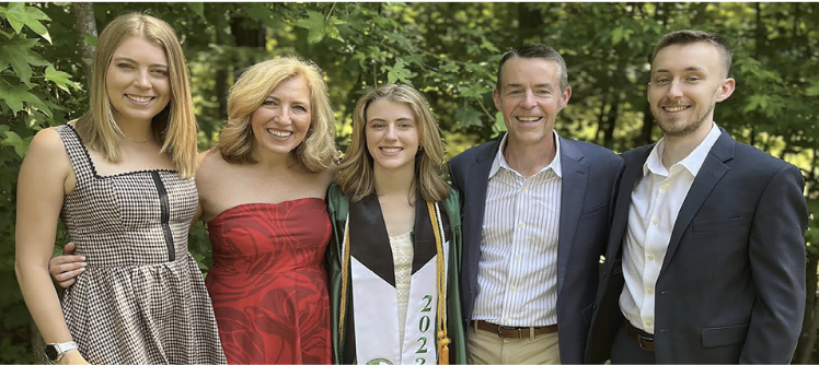 A family poses for a group photo for the youngest daughter's high school graduation